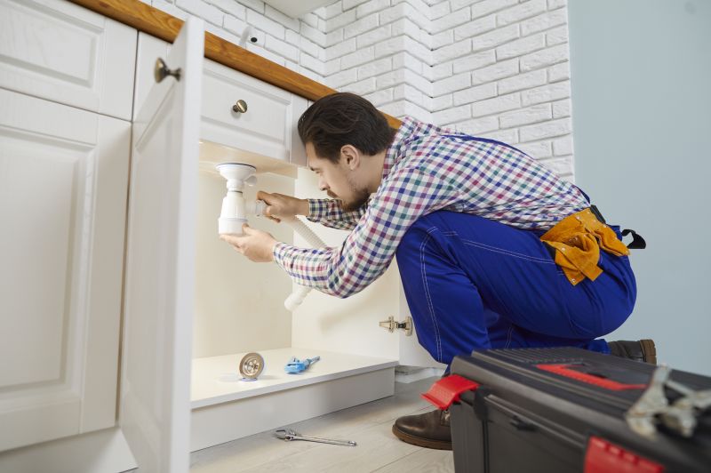 Plumber Working Under Sink